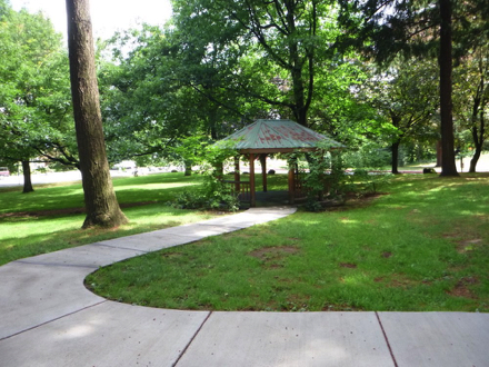 The main trail connects to a sidewalk that passes a covered gazebo, picnic tables, restroom, basketball and playground